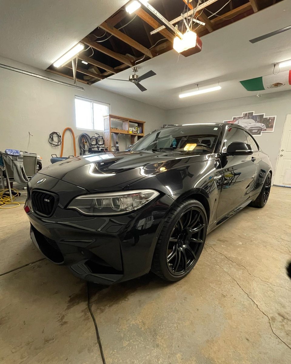 Black BMW M2 inside the detail bay